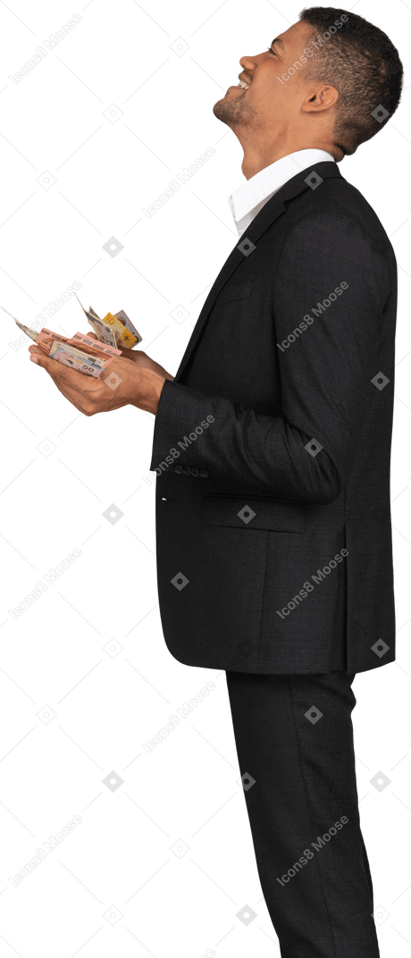 Side view of a young man in black suit holding banknotes