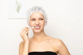 Young woman holding syringe with her teeth