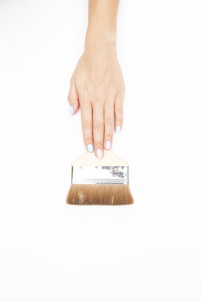 Female hands holding paint brush