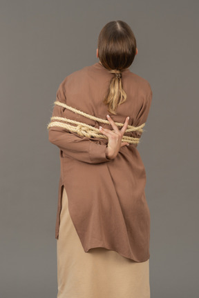 Back view of a tied woman reaching a rope
