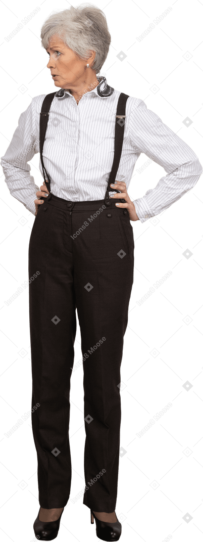 Vista frontale di una vecchia signora scontenta in abiti da ufficio che mette le mani sui fianchi