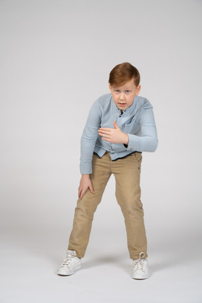 Young boy in blue shirt and khaki pants pointing left