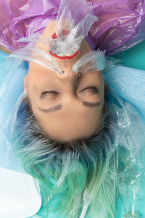 Young woman lying with her eyes closed surrounded with lots of plastic things
