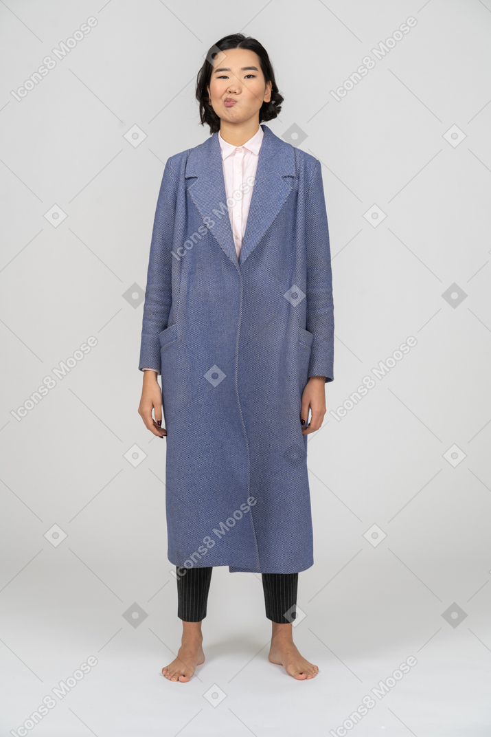Front view of a woman in blue coat making a silly face