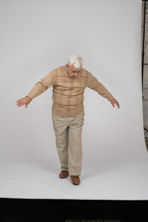 Вид спереди на старика в повседневной одежде, идущего вперед