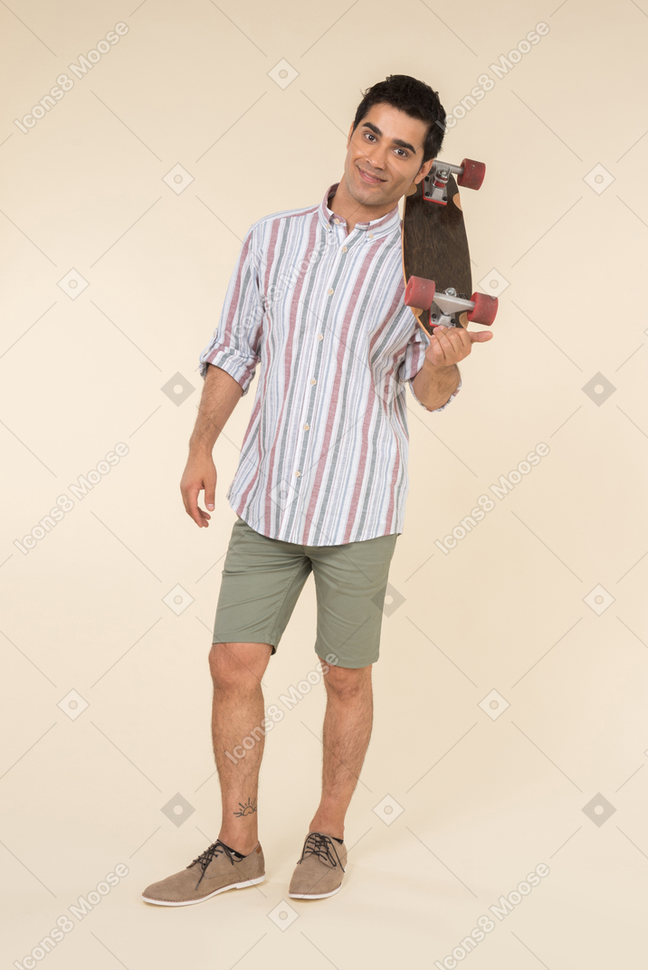 Young caucasian guy holding skate