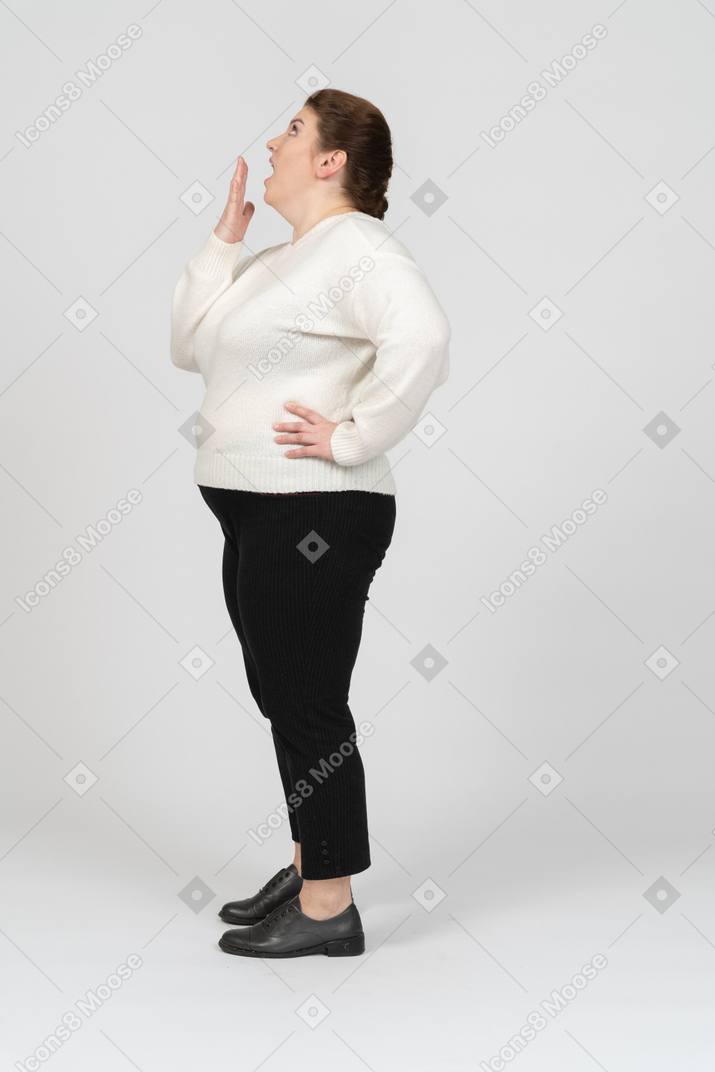 Impressionata donna grassoccia in piedi di profilo