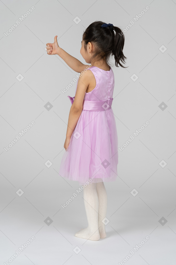 Three-quarter back view of a little girl giving thumbs up