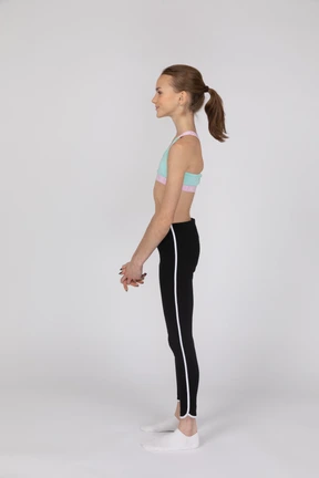 Side view of a teen girl in sportswear raising hand and arguing