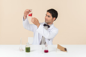 Hombre científico sentado en la mesa y mirando la mesa