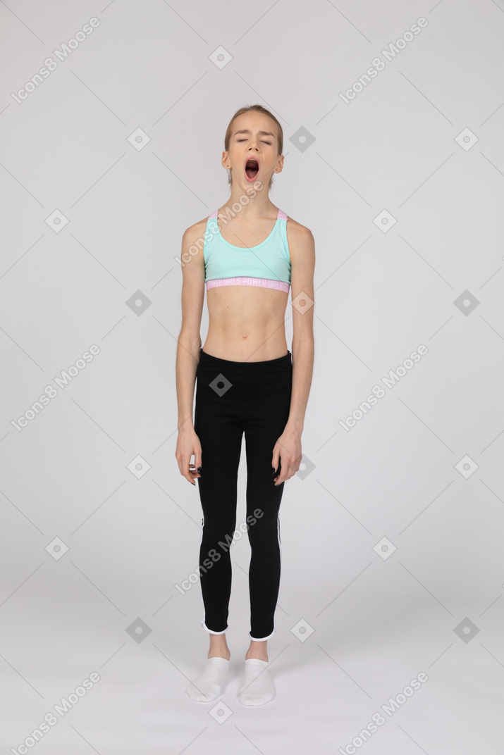 Уставшая девочка-подросток в спортивной одежде зевает