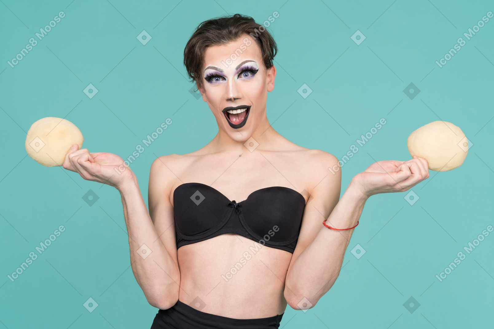 Drag queen looking excited and holding bra inserts