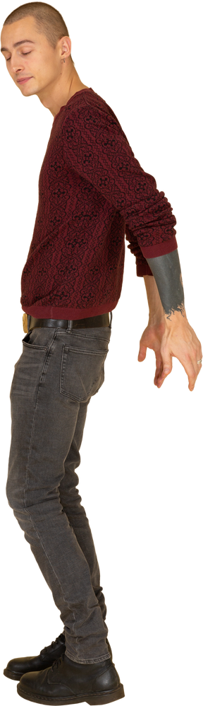 Side view of a young man in red pullover taking hands behind