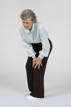 Old woman touching her sore knee