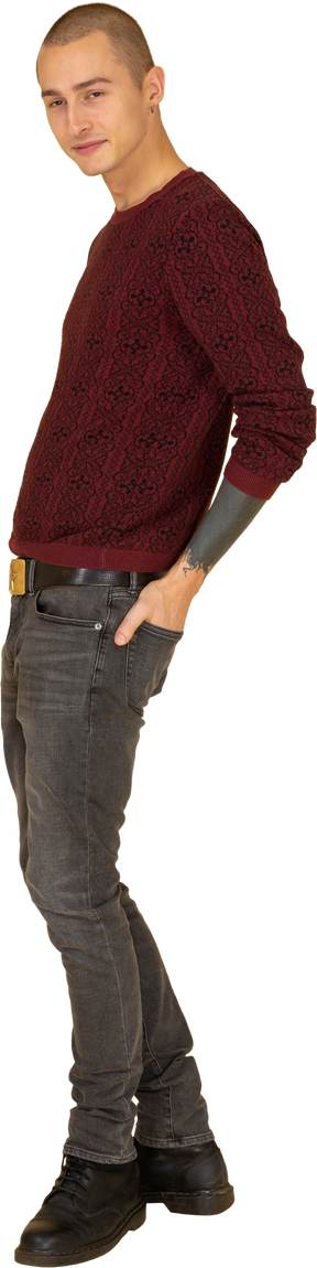 一个年轻人在红色的套衫，将手放在后兜里的侧视图