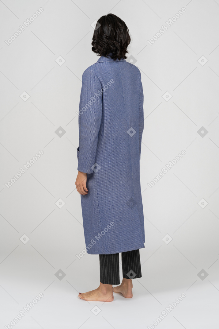 一个穿着外套的女人的背影，双臂在两边站着