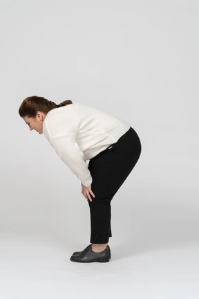Plump woman in casual clothes suffering from pain in lower back