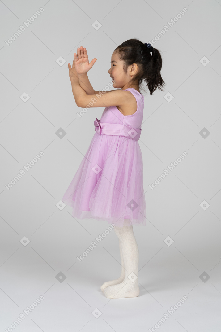 Side view of a cute little girl making stop sign by crossing her arms