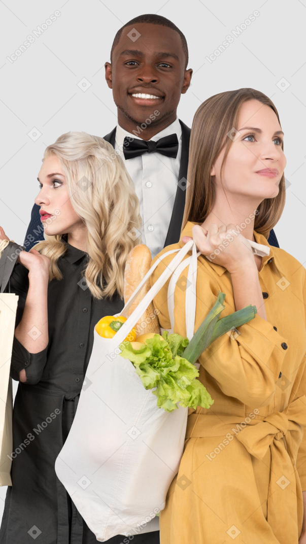 A group of people standing next to each other holding shopping bags