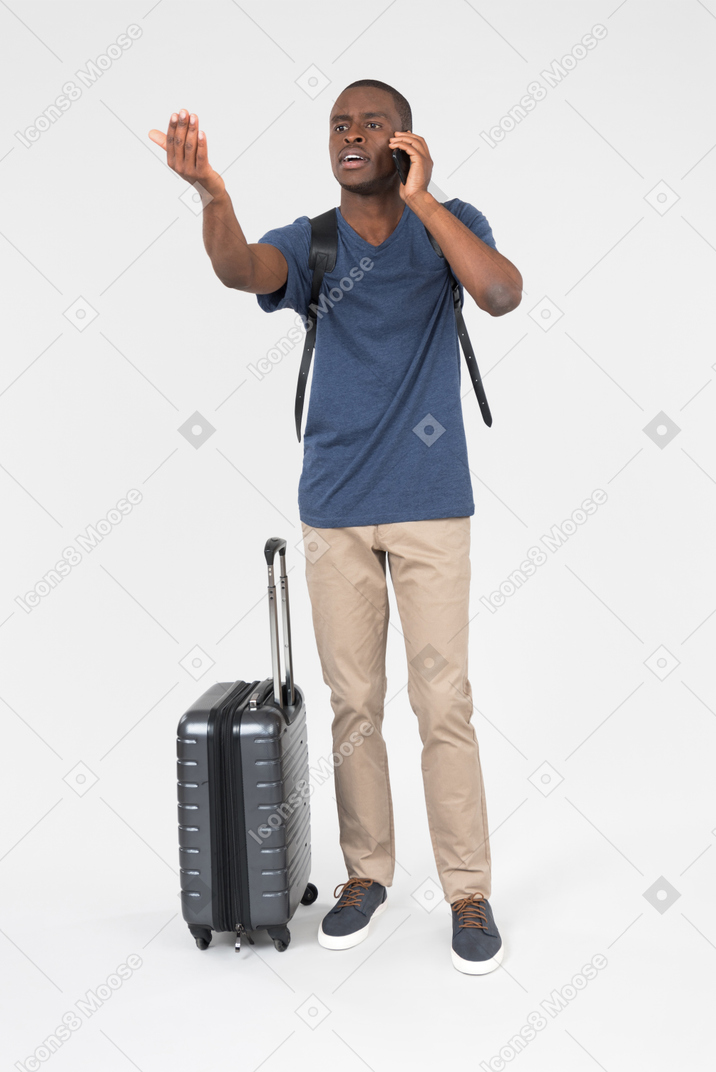 Male tourist talking on the phone and showing to stop with a hand