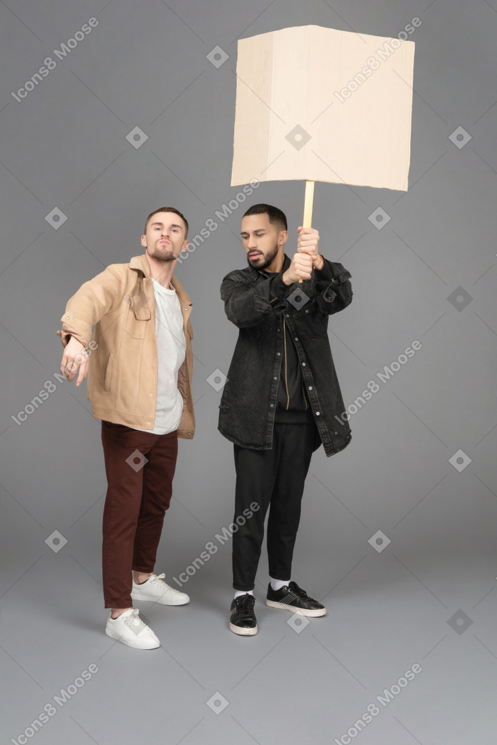 Front view of two young men raising a billboard passionately
