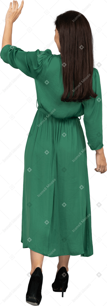 Back view of a greeting young lady in green dress