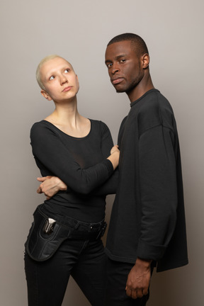 Jeune homme debout avec une femme et regardant la caméra