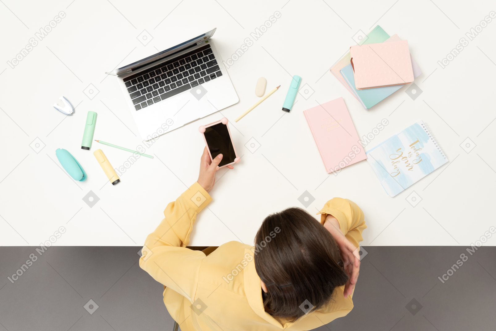 A female office worker at the table holding phone