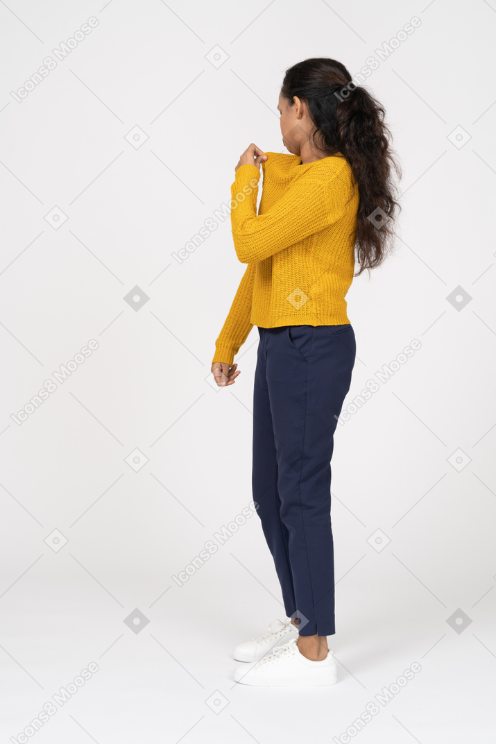 Side view of a girl in casual clothes checking her shirt