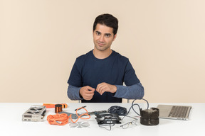 A young man in casual blue clothes working with computer details