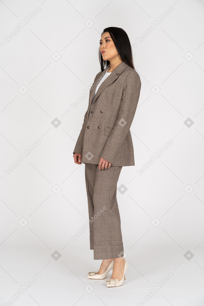 Three-quarter view of a pouting young lady in brown business suit
