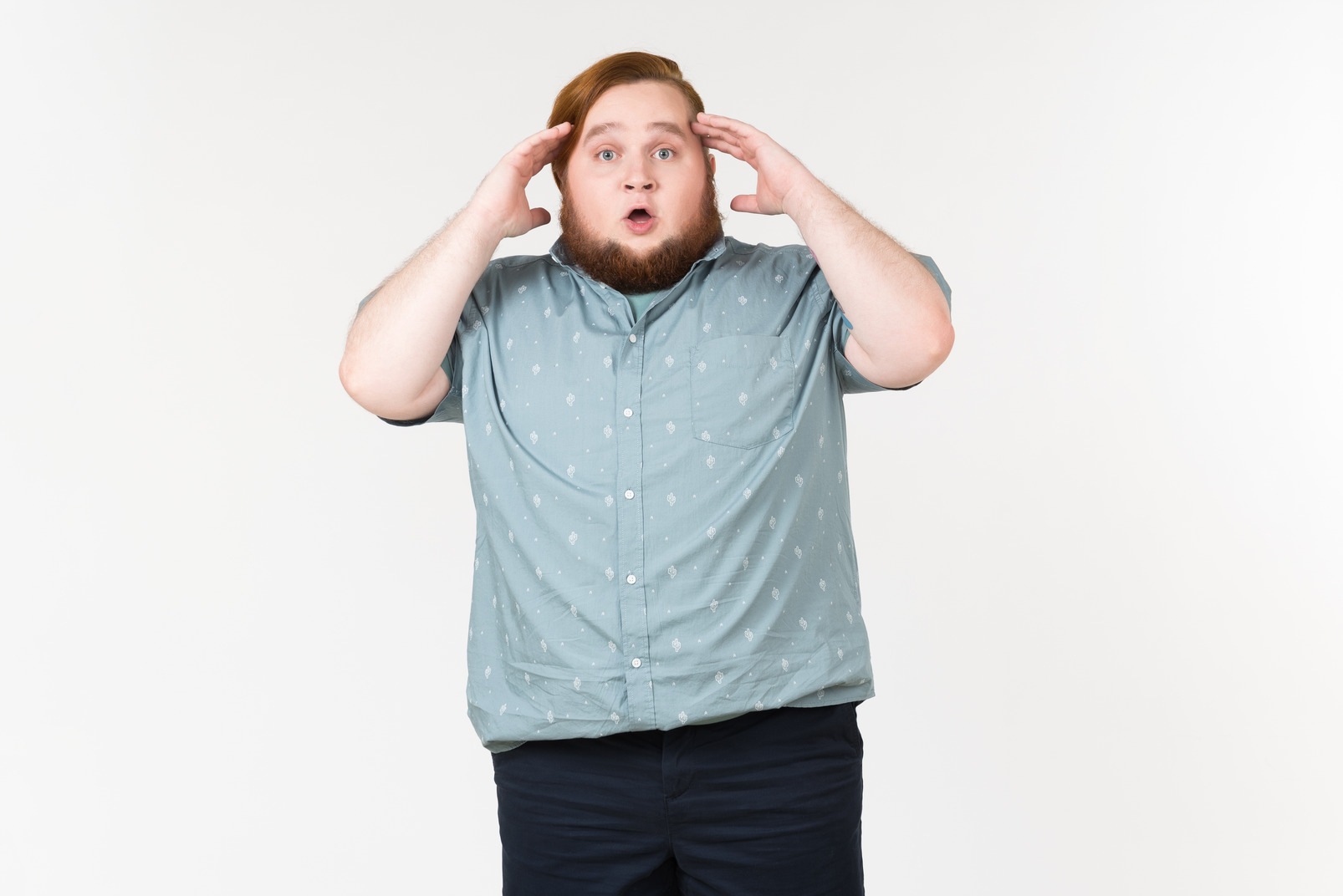 Blown away young overweight man touching his head