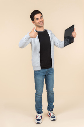 Young caucasian man pointing at digital tablet he's holding