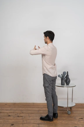 Side view of a man in suit showing thumbs up