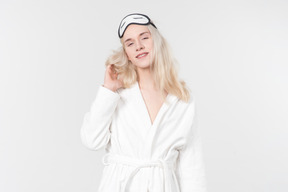 Young blond-haired man in a white bathrobe going about his morning routine