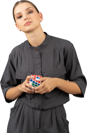 Vue de face d'une jeune femme en combinaison tenant le rubik's cube