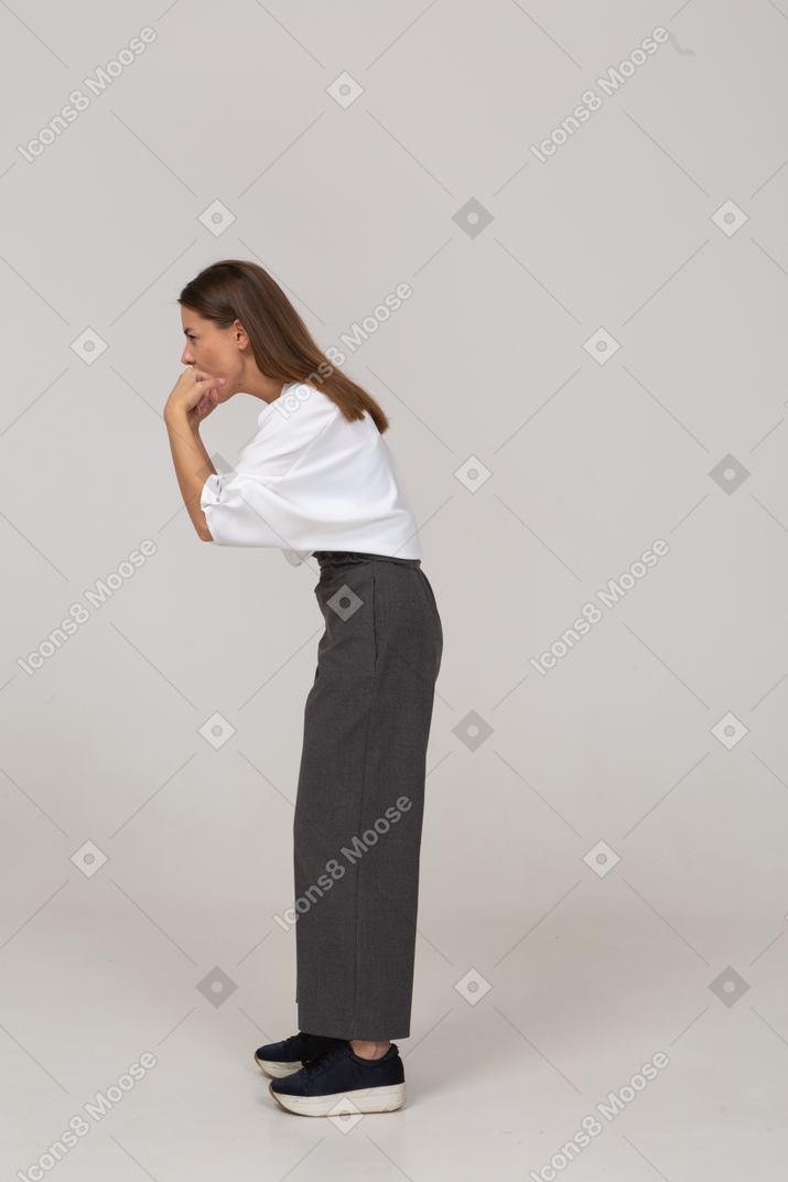 Vista lateral de uma jovem assobiando com roupas de escritório, inclinada para a frente