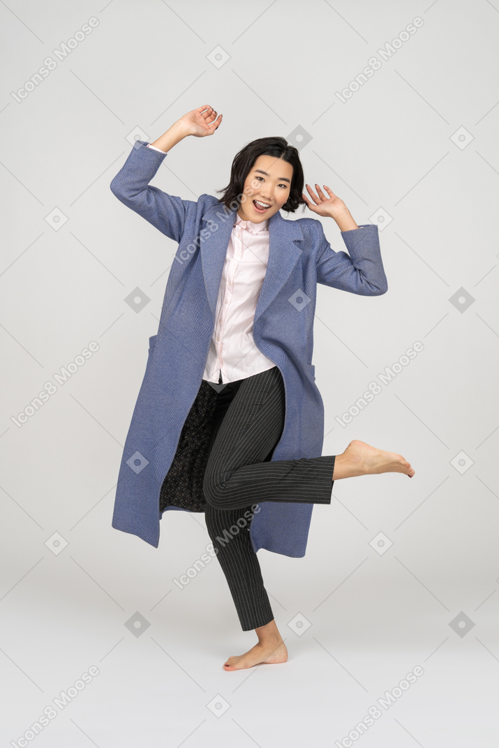 Mujer feliz bailando en una pierna