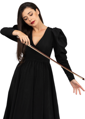 Vue de face d'une jeune femme en robe noire tenant l'arc