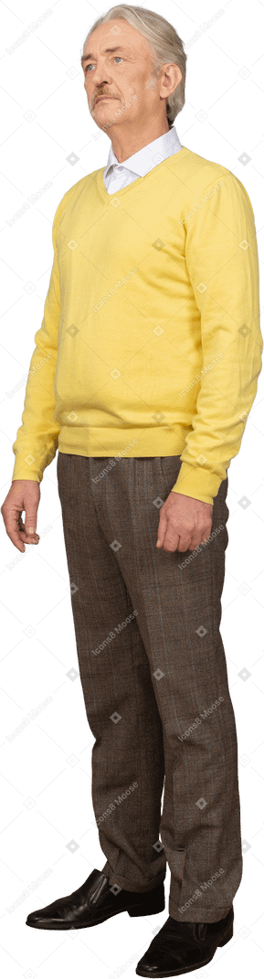 Three-quarter view of an old man wearing yellow pullover and standing still