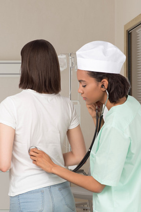 Femme médecin examine un patient