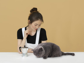 Linda menina asiática e um gato de pêlo curto britânico