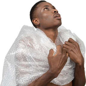 Gros plan un homme africain dans une pellicule plastique debout dans une pose religieuse