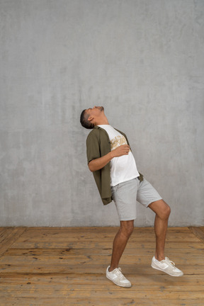 Man in casual clothes throwing his head back