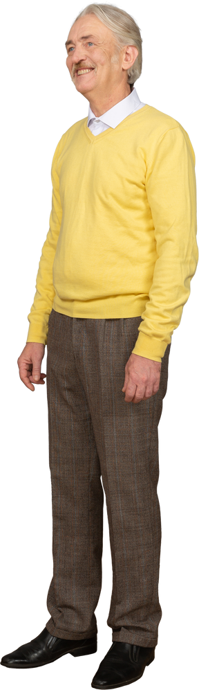 Vista di tre quarti di un vecchio sorridente che indossa un pullover giallo e guarda da parte