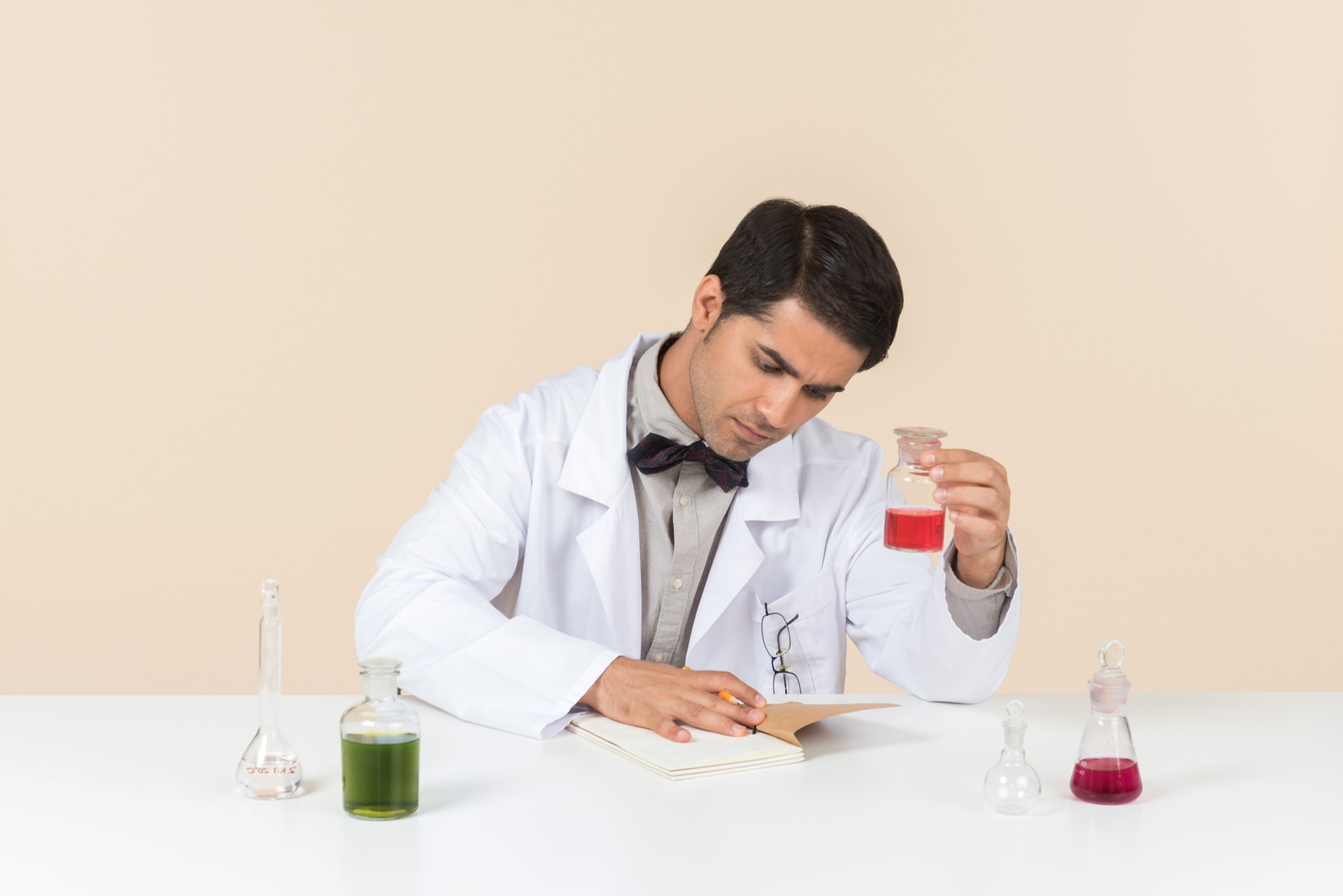 Male scientist holding bulb and sitting at the table