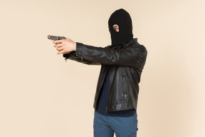 Homem em balaclava mirando com uma arma