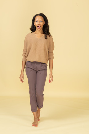 Vista frontal de una mujer joven en ropa casual mostrando la lengua