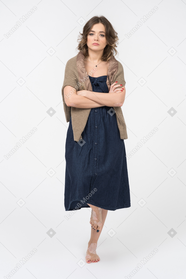 Cheerless girl balancing on one leg and keeping hands folded