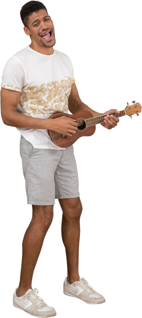 Three-quarter view of a man singing and playing ukulele